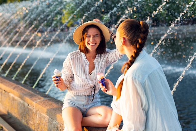 Kostenloses Foto beste freunde sitzen neben brunnen