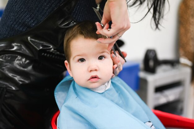 Friseur Der Das Haar Anredet Ein Kleines Dunkelhaariges Madchen Tut Premium Foto