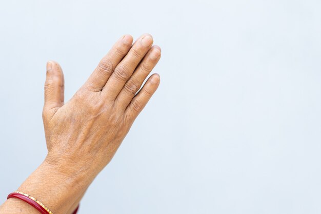 Betende Hände einer Person auf einem grauen Hintergrund