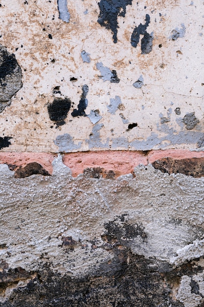 Betonmauer mit Ziegelsteinen und schmutzigen Flecken