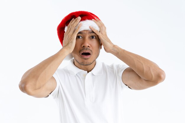Betonter Mann, der Weihnachtsmann-Hut trägt und Kopf erfasst
