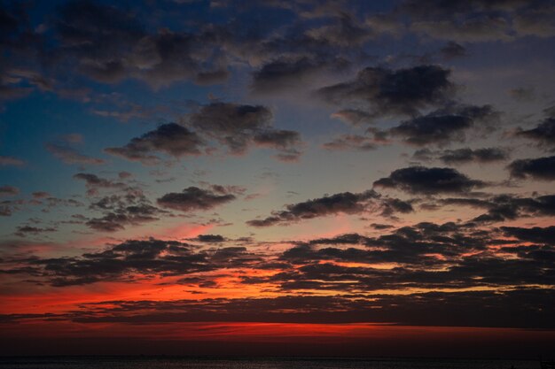 Bewölkter Himmel in einem Sonnenuntergang in Meer