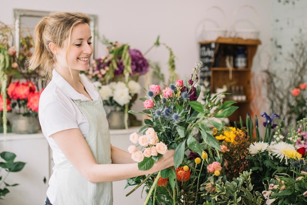 Bewunderter Blumenstrauß des lächelnden Floristen