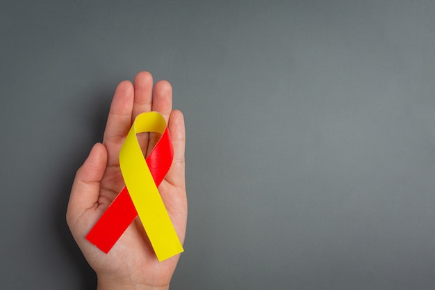 Bewusstsein zum Welthepatitis-Tag mit rot-gelbem Band