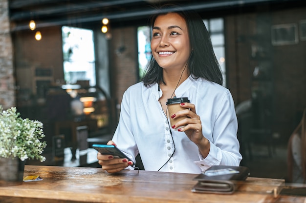 Bezahlen Sie Kaffee mit Kreditkarte über ein Smartphone im Café