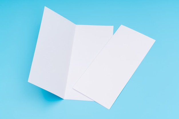 Bifold weiße Vorlage Papier auf blauem Hintergrund.