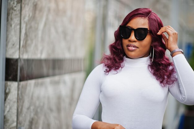 Big Mama Plus Size afroamerikanisches Model in schwarzer Sonnenbrille und Lederrock posierte im Freien