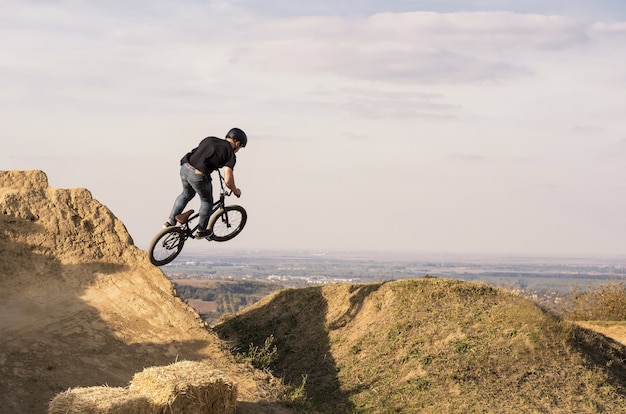 Biker springt und fliegt über einen Hügel