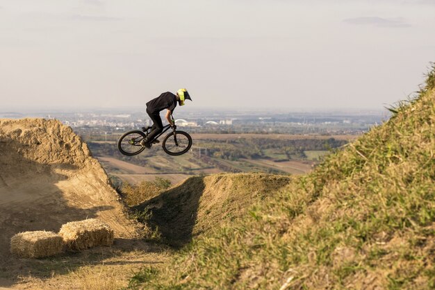 Biker springt und fliegt über einen Hügel