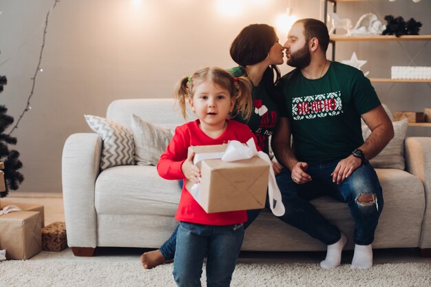 Bild der kaukasischen Familie mit einem hübschen weiblichen Baby feiert Neujahr oder Weihnachten