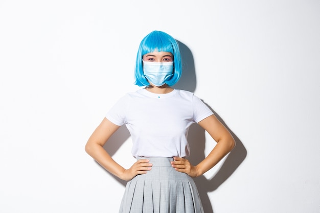 Bild des fröhlichen asiatischen Mädchens bereit für Halloween-Party, schützen Sie sich vor Coronavirus als medizinische Maske tragend