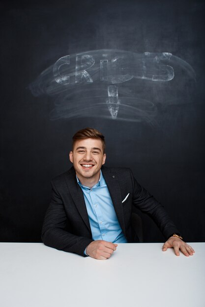Bild des lächelnden Mannes über Tafel mit Kriseninschrift