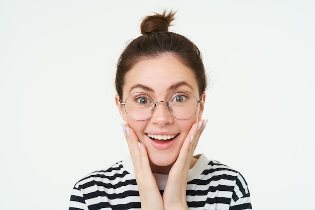 Kostenloses Foto bild einer erstaunten lächelnden jungen frau in brille, die eine brille trägt und beeindruckt und aufgeregt aussieht