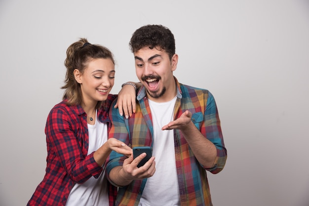 Bild einer jungen Frau, die das Handy ihres Mannes betrachtet.