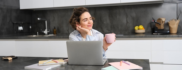 Kostenlose Foto bild einer jungen frau, die eine tasse kaffee trinkt und von zu hause aus arbeitet