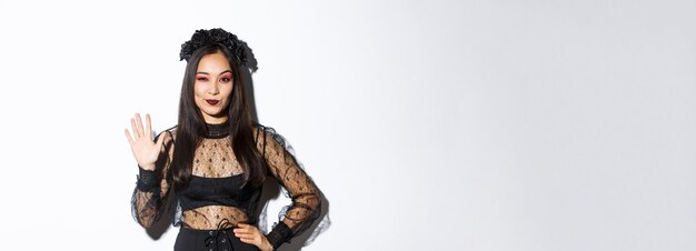 Bild einer selbstbewussten, schönen Asiatin im Halloween-Kostüm, die fünf Finger zeigt, die die Hand nach s heben