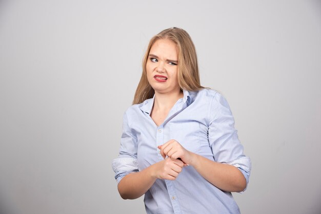 Bild eines jungen Frauenmodells, das ein blaues T-Shirt trägt und posiert