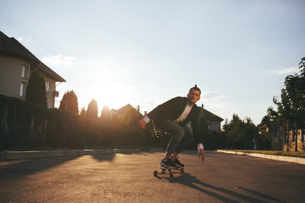 Bild eines Mannes mit dem longboard, das auf Straße geht