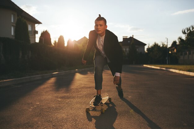 Bild eines mannes mit dem longboard, das auf straße geht