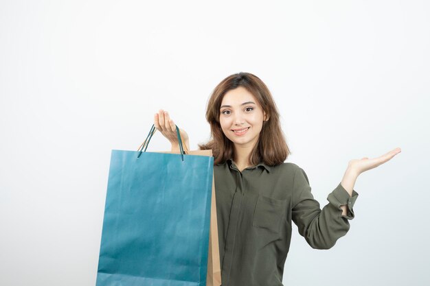 Bild eines schönen kurzhaarigen Mädchens mit stehenden Einkaufstüten. Foto in hoher Qualität