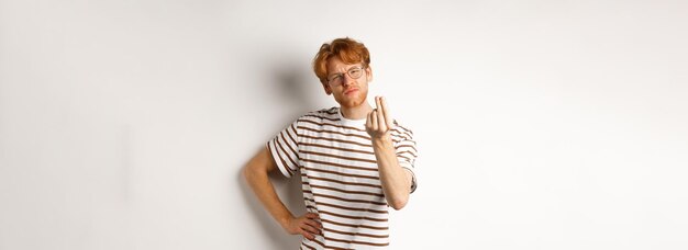 Kostenloses Foto bild eines zufriedenen jungen mannes mit roten haaren und brille, der köche mit einer kussgeste zeigt, um etwas zu loben