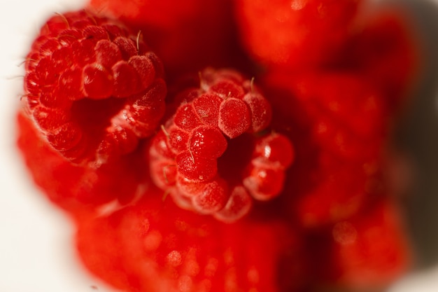 Bild von Himbeeren in Dreiecksform liegt isoliert auf weißem Hintergrund. Ausschneiden, Nahaufnahme. Hintergrund und Bild für Postkarte.