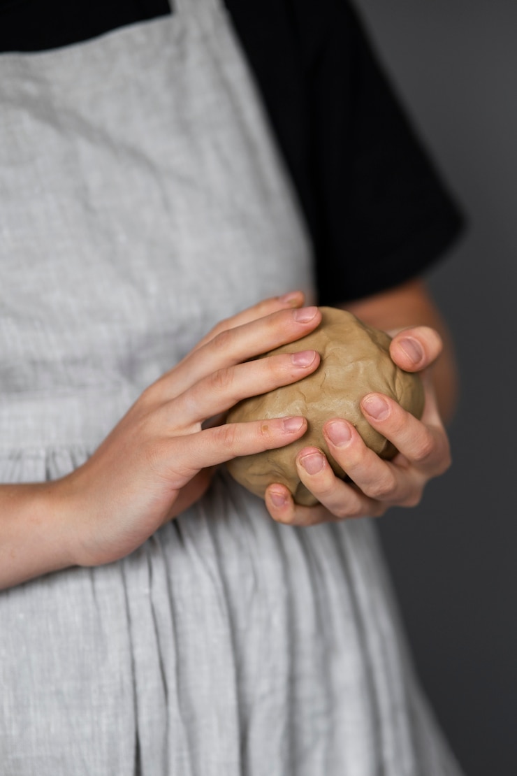 Kostenlose Foto bildhauerin, die im atelier mit ton arbeitet