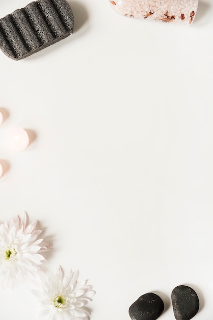 Bimsstein; Salz; Letzter; Kerzen und Blumen auf weißem Hintergrund