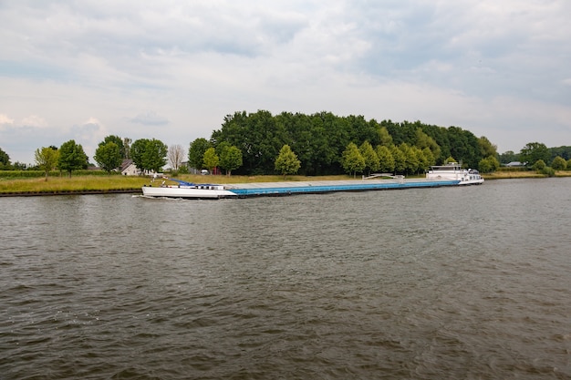 Binnenschiff bei bewölktem Himmel in den Niederlanden