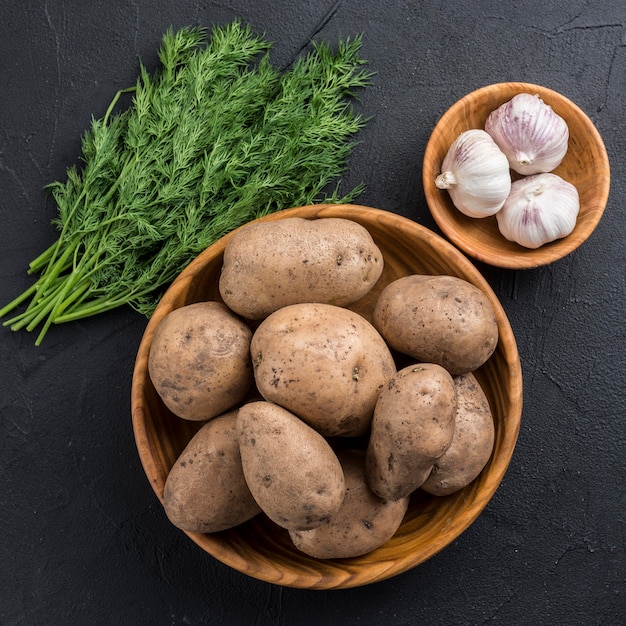 Bio-Kartoffeln in Schüssel und Knoblauch