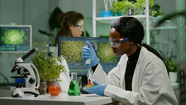 Biologe Wissenschaftler afrikanische Forscherin, die genetische Lösung aus dem Reagenzglas nimmt