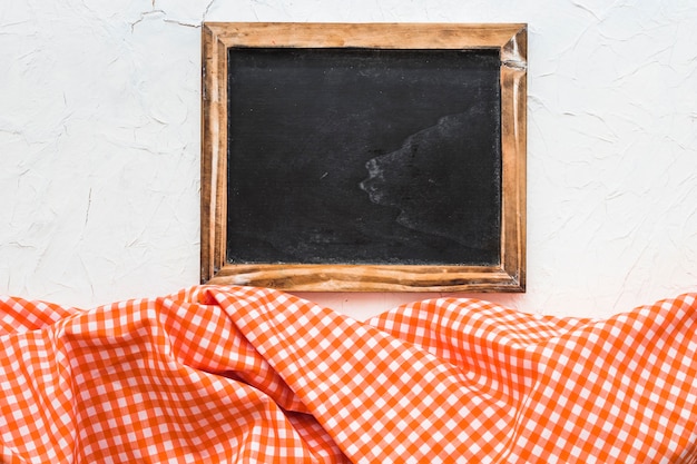 Blackboard in der Nähe von kariertem Stoff