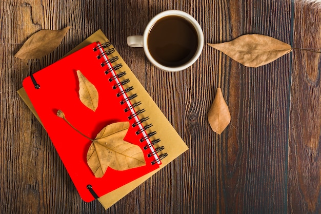 Kostenloses Foto blätter und kaffee in der nähe von notizblöcken