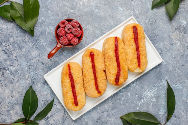 Blätterteigplätzchen mit Himbeermarmelade und gefrorenen Himbeeren auf Licht