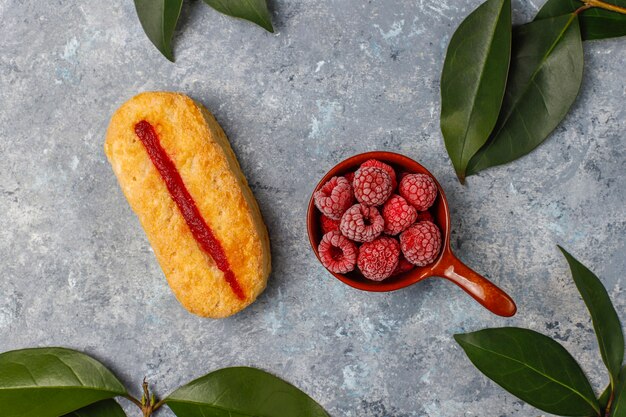 Blätterteigplätzchen mit Himbeermarmelade und gefrorenen Himbeeren auf Licht