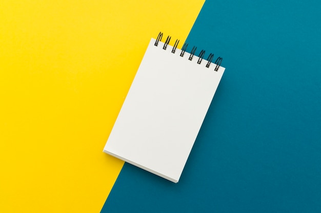 Blank Notepad auf gelbem und blauem Hintergrund