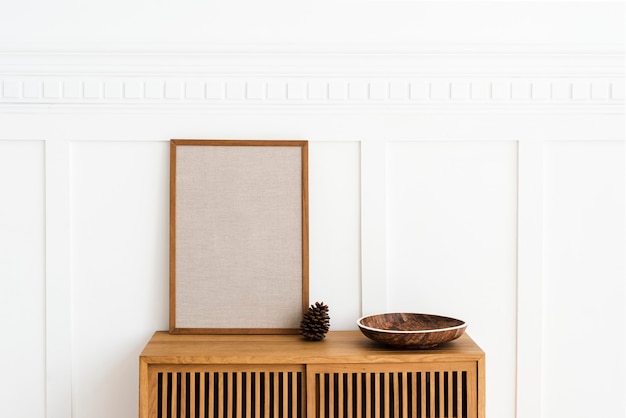 Blanker großer Rahmen auf einem Holz-Sideboard in einem Wohnzimmer