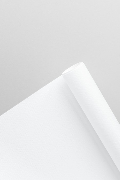 Blankes weißes gerolltes Diagrammpapier auf grauem Hintergrund