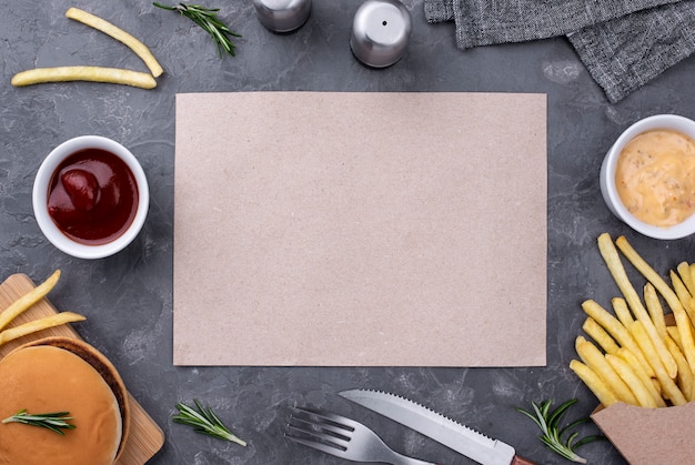 Blatt Papier neben Hamburger und Pommes