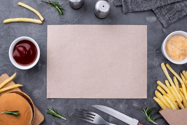 Blatt Papier neben Hamburger und Pommes