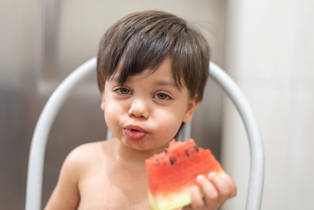 Blauäugiges Baby, das Wassermelone isst