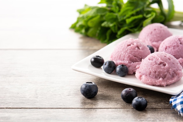 Blaubeereiskugeln auf Holztisch Platz kopieren