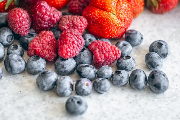 Kostenloses Foto blaubeeren, himbeeren und erdbeeren auf dem küchentisch in großaufnahme