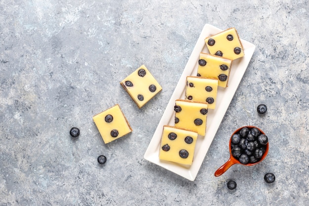 Kostenloses Foto blaubeerkäsekuchenriegel mit honig und frischen beeren