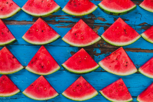 Blaue Holzoberfläche mit Wassermelonen Portionen