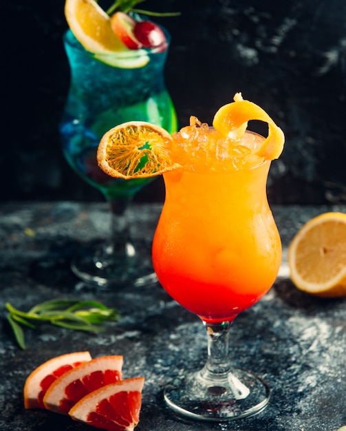 Blaue Lagune und orange Cocktails mit Fruchtscheiben.