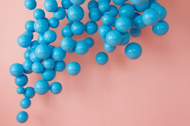 blaue Luftballons, blaue Blasen auf rosa Hintergrund. Moderne kräftige Pastellfarben