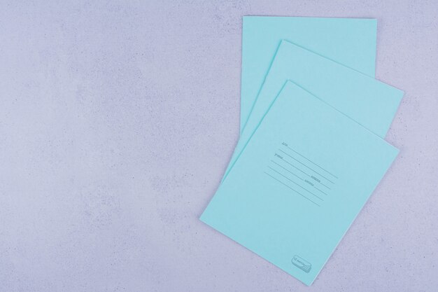 Blaue Notizbücher isoliert auf grauer Oberfläche