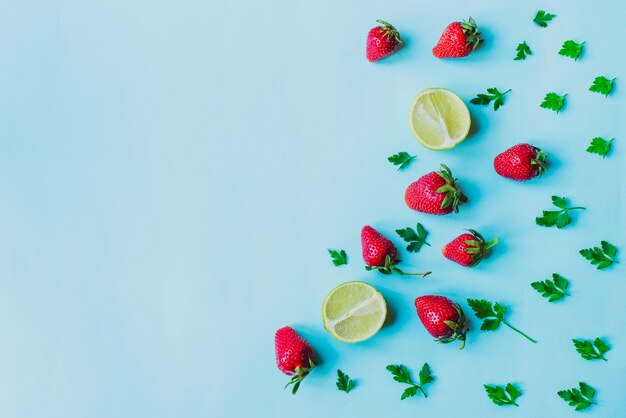 Blaue Oberfläche mit Erdbeeren und Limetten