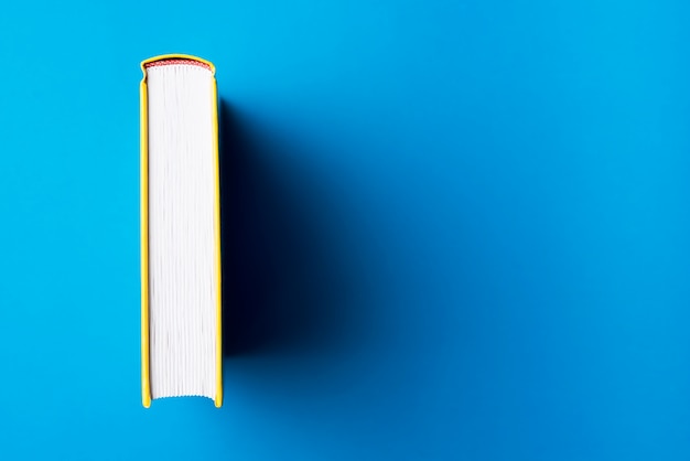 Blaue Oberfläche mit gelbem Buch und Platz für Nachrichten